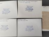 four envelopes with handwritten letters on them sitting on top of a table