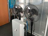 deux ventilateurs posés à côté d'un radiateur
