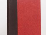 a red and black book sitting on top of a white table