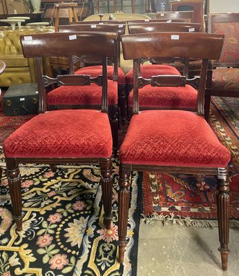 quatre chaises aux sièges rembourrés de rouge dans une pièce