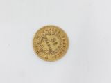 a close up of a gold coin on a white surface