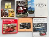 plusieurs livres posés sur une surface blanche, avec un bus rouge en arrière-plan