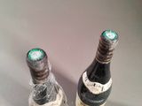 two bottles of wine that are sitting on a table
