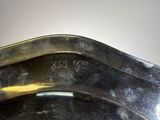 a close up of a metal bowl with a handle