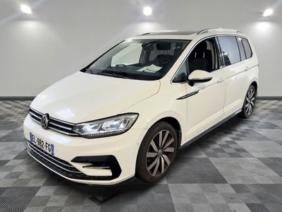 a white volkswagen touran parked in a room with checkered floor