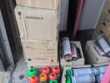 Des cartons contenant des objets divers sont empilés sur le sol devant une porte.