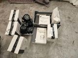 many boxes of electronic equipment on the floor next to a bed