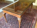 une table en verre avec un piètement en bois posée sur un tapis