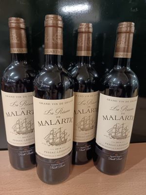 quatre bouteilles de vin sont alignées sur un comptoir