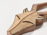 a wooden sculpture of a horse ' s head on a white surface