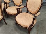 four chairs with upholstered arms and arms are sitting in a room