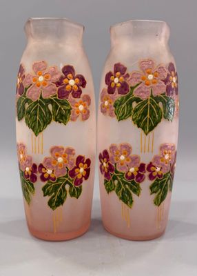 une paire de vases roses ornés de fleurs violettes et de feuilles vertes