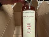 quelqu'un tient une bouteille de vin dans une boîte en carton