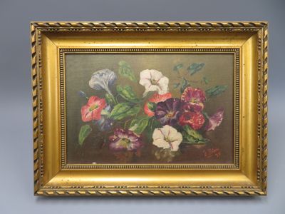 une peinture à l'huile représentant des fleurs, dans un cadre doré, accrochée à un mur bleu