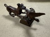 une statue représentant un chien et un oiseau posée sur une table