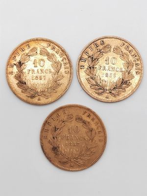 trois types différents de pièces d'or sur une surface blanche