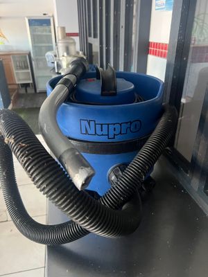 une photo d'un aspirateur bleu posé sur un plan de travail
