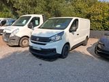 several white vans parked in a parking lot with trees in the background