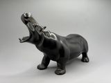 statue d'un hippopotame avec la bouche ouverte, la bouche grande ouverte