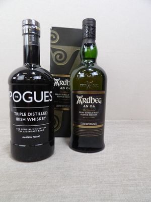 deux bouteilles de scotch et une caisse de whisky posées sur une table