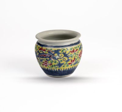 a small blue and yellow vase on a white surface