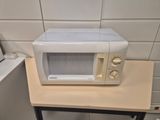 a microwave sitting on a small table in the kitchen