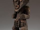 a wooden statue of a man with a mohawk on his head