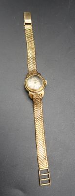 a close up of a gold watch on a black surface