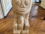 une statue représentant un homme assis sur une chaise dans un salon