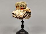 une sculpture représentant un animal en peluche posée sur un socle noir