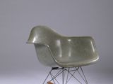 un fauteuil à bascule avec une assise en bois et un piètement en métal