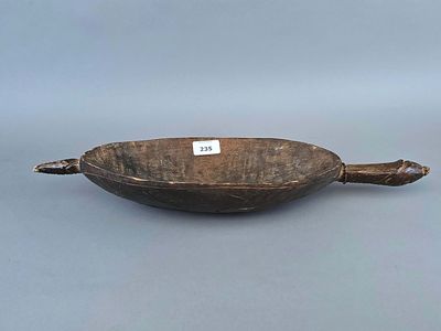 un vieux bol en bois posé sur une surface grise