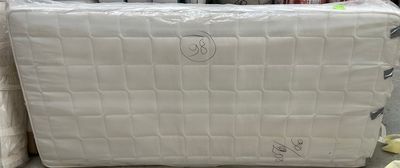 Plusieurs cartons de matelas sont empilés par terre dans un magasin.