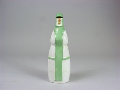 une figurine verte et blanche représentant une femme coiffée d'un chapeau