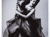 photographie en noir et blanc d'une femme en robe tenant une guitare
