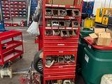 de nombreux outils posés sur un chariot rouge dans un garage