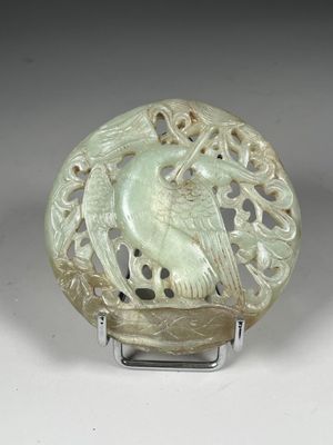 an image of a green jade carving of a bird on a stand