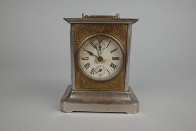 une petite horloge en argent ornée de chiffres romains