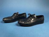 a pair of black leather shoes on a blue background