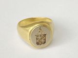 an image of a gold ring with a coat of arms on it