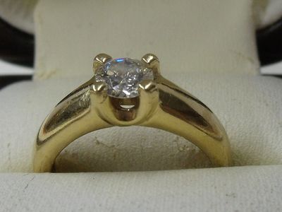 Bague solitaire en or jaune 18K, sertie d’un diamant de tail…