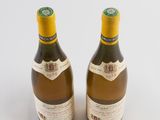 two bottles of wine sitting next to each other on a white surface