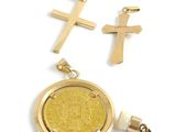 two gold crosses and a gold coin are on a white surface