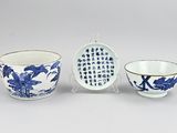 three blue and white porcelain bowls and a bowl with writing on them