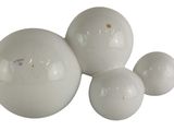 three white balls sitting next to each other on a white surface