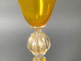 a yellow wine glass with a twisted stem on a table