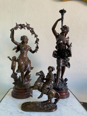 une statue représentant une femme et un chien posée sur une table