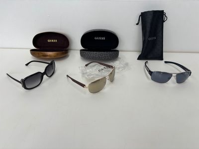 three pairs of sunglasses and a case on a white surface