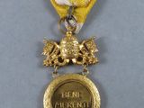 the medal is gold and has a white ribbon around it