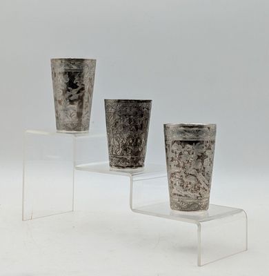 trois vases posés sur un socle transparent, sur une surface blanche